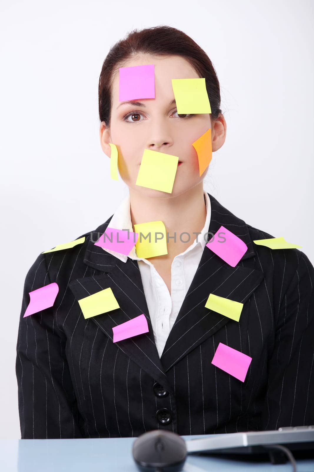 Beautiful caucasian businesswoman sitting in the office with post it notes on her body.