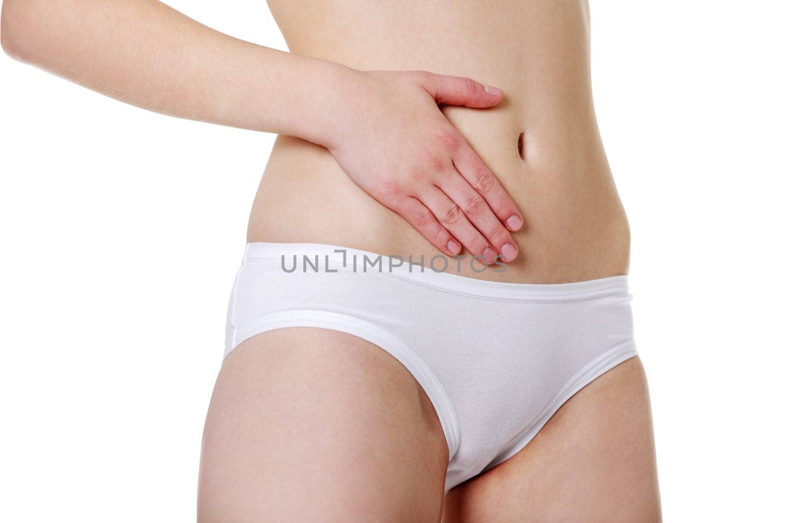 Sit view of a fit young girl holding a hand on her sexy thigh, dressed in white underwear, isolated on white beckground.