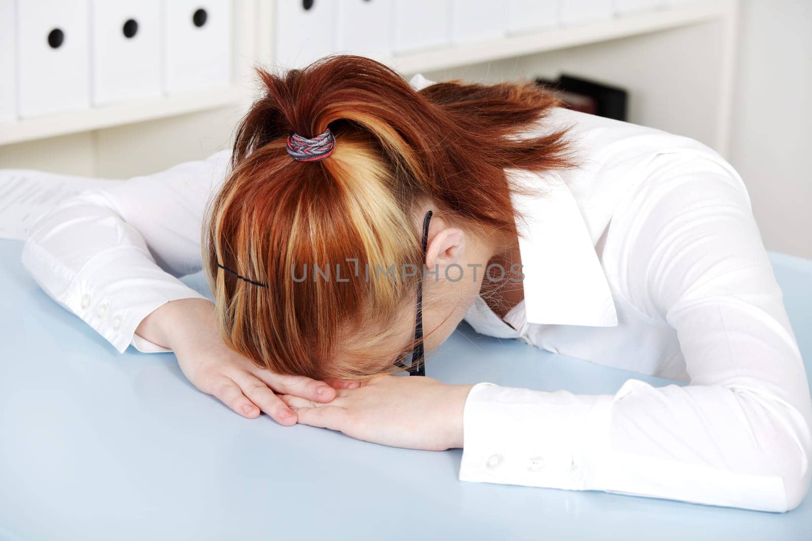 Young woman laying on the desk in the office.