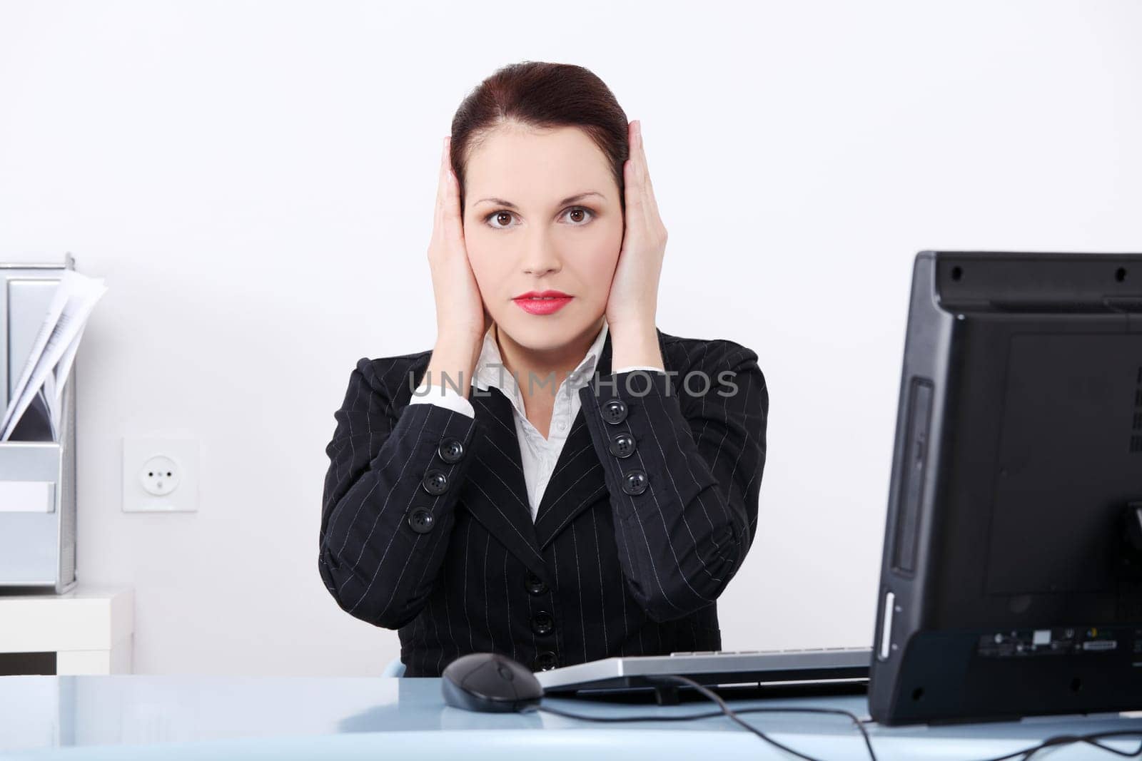Pretty caucasian businesswoman in the hear no evil pose.