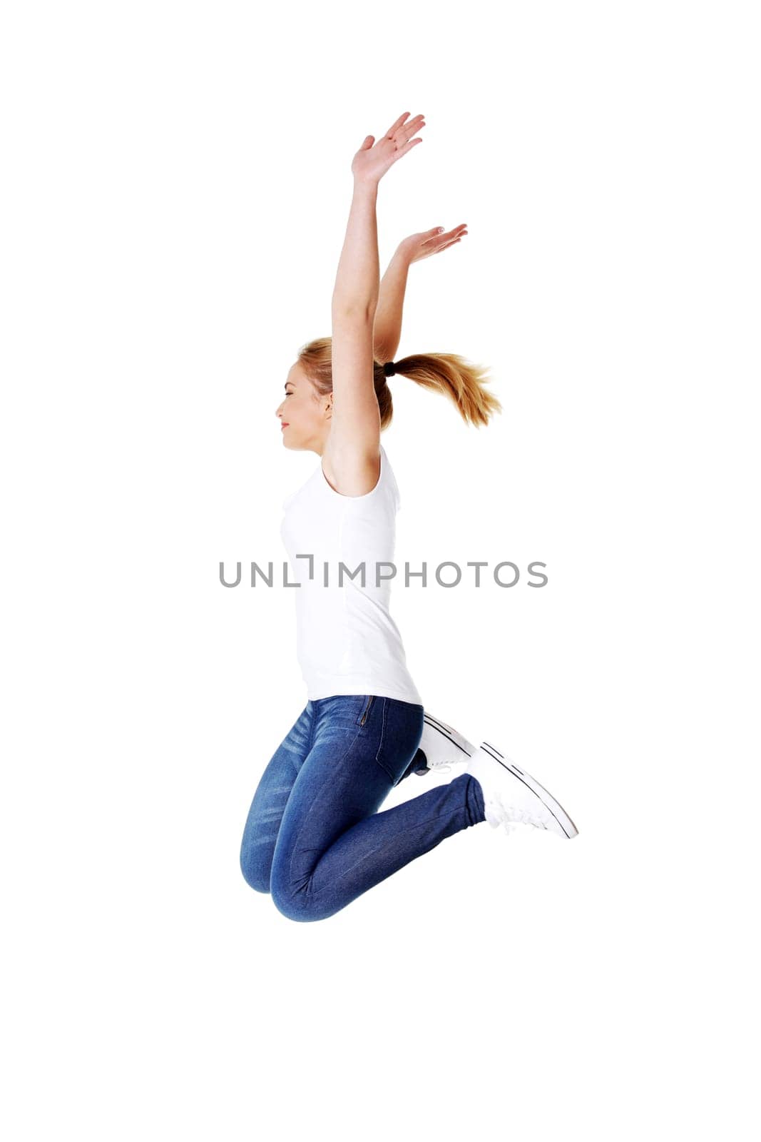 Young happy caucasian woman jumping in the air , isolated on white background