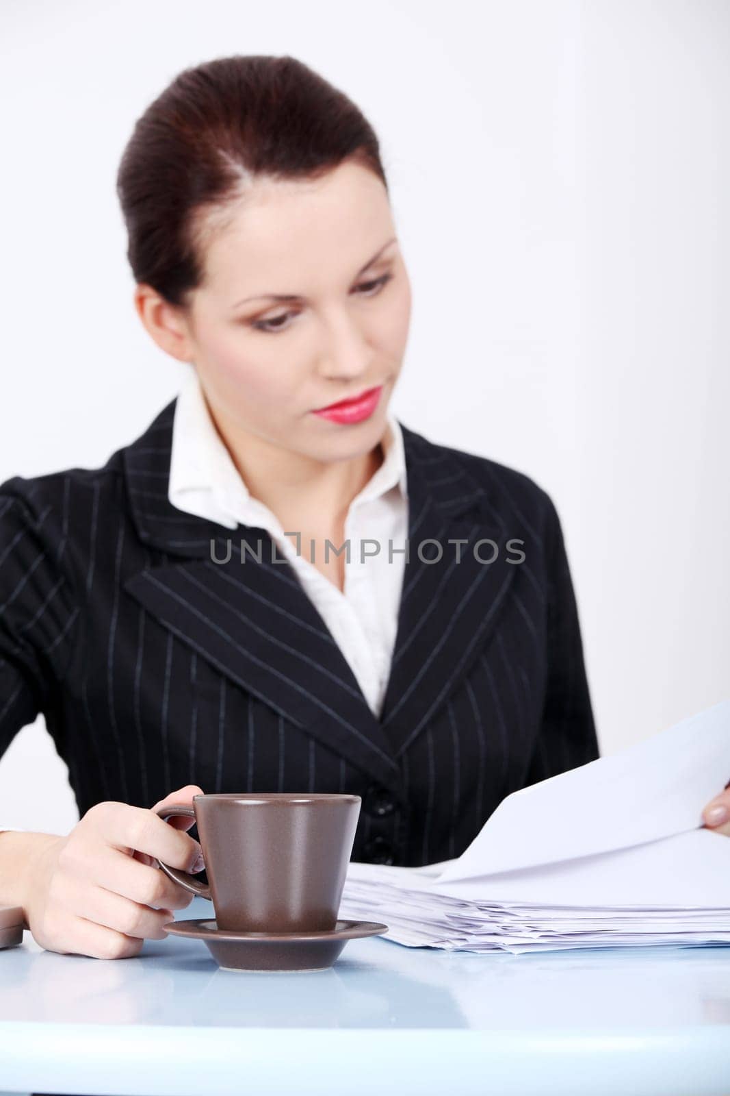 Pretty caucasian working businesswoman sitting in the office holding mug.