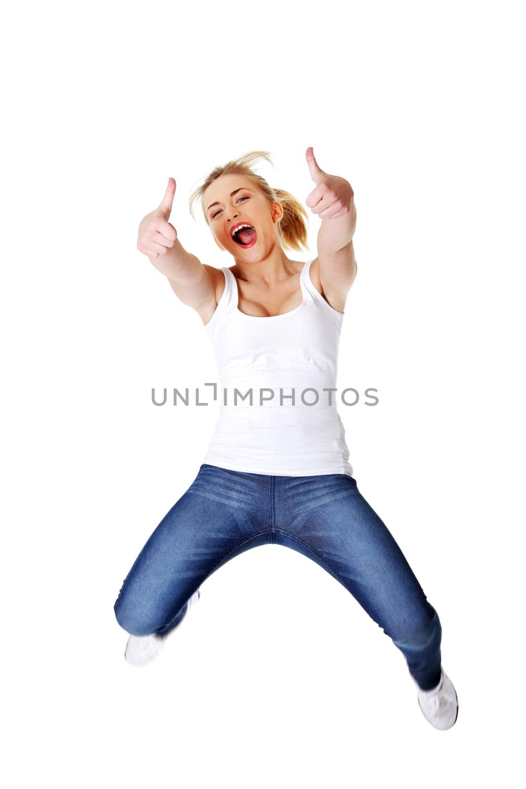 Young happy caucasian woman jumping in the air with thumbs up , isolated on white background