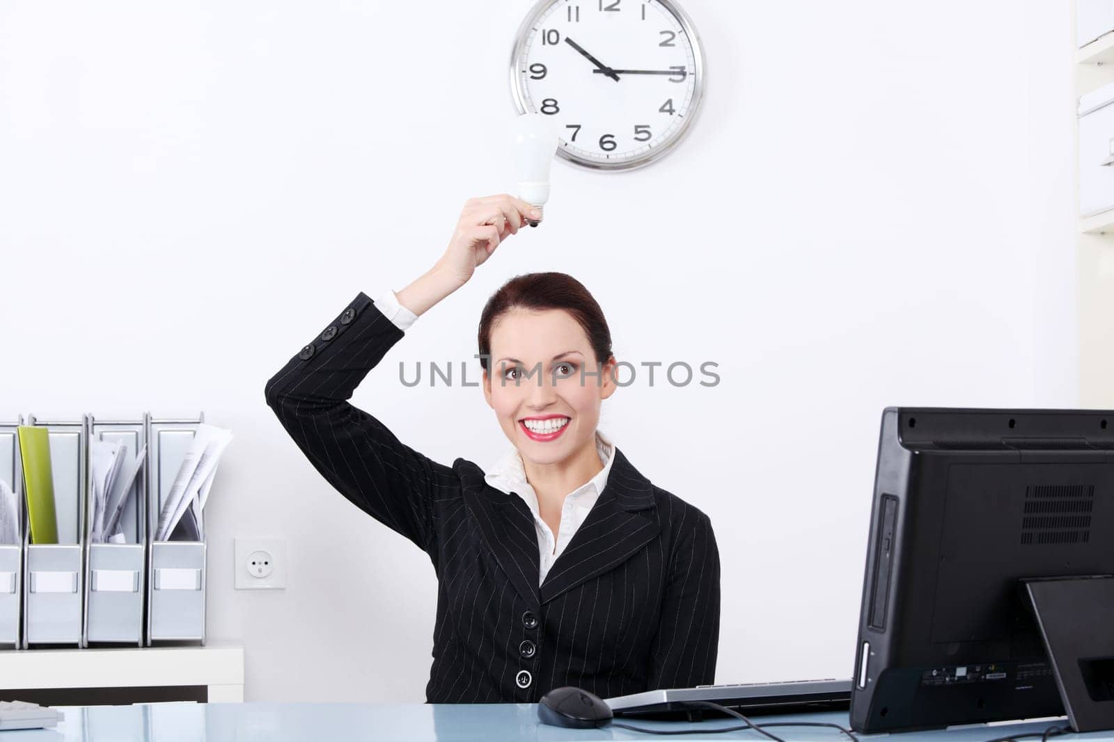 Pretty caucasian businesswoman holding a light bulb in the office.