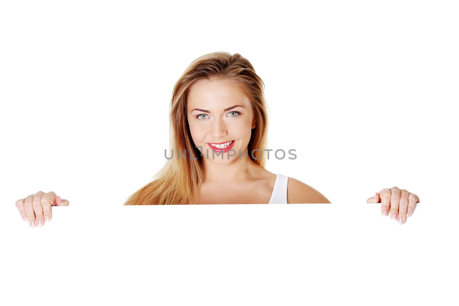 Beautiful blond teen girl behind big blank billboard, isolated on white background