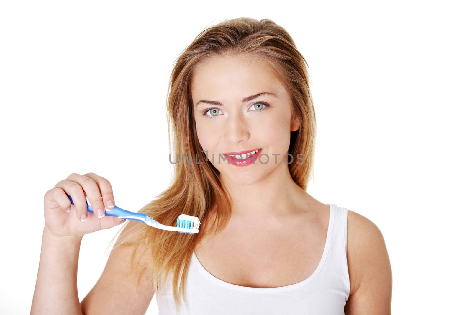 Beautiful blond teen woman brushing her teeth
