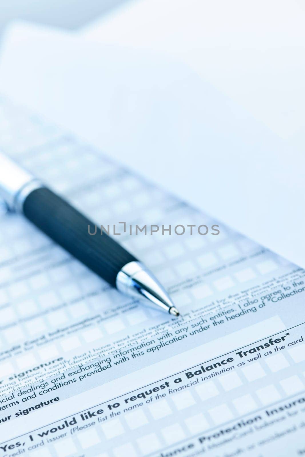 Blank credit application form with envelope and pen close up