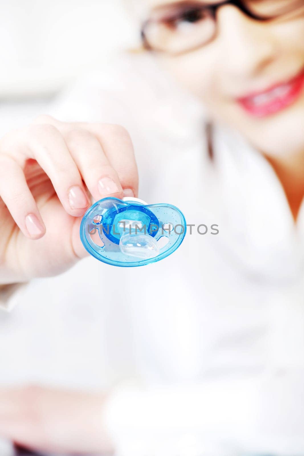 Young businesswoman in glasses giving a dummy to her child in the office.