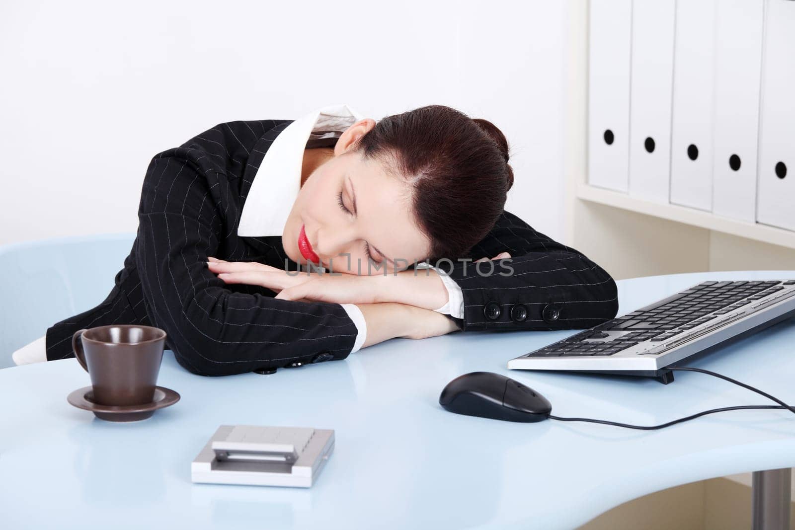 Beauty caucasian businesswoman sleeping on the desk in the office.