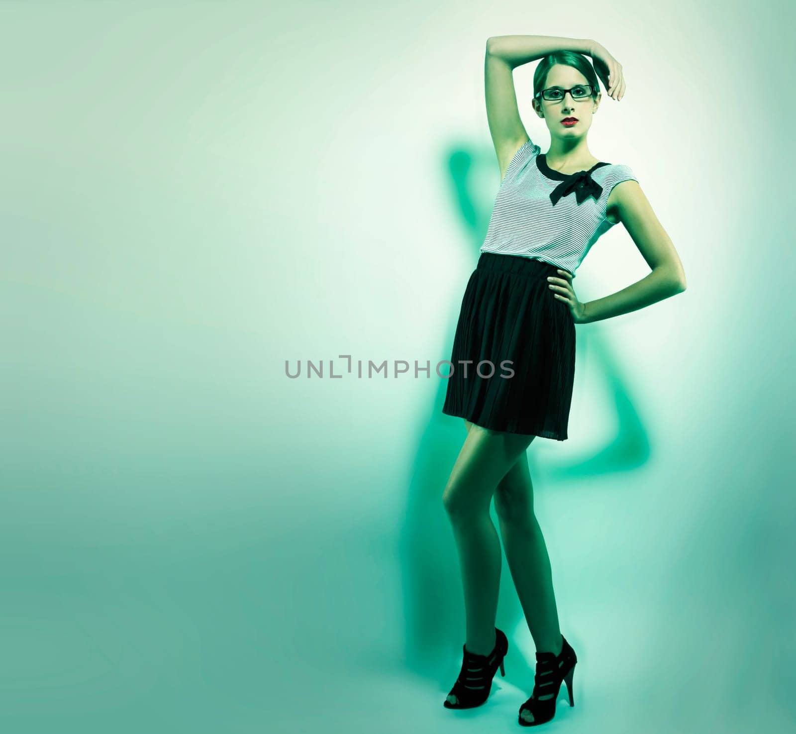 Beautiful woman in fashion pose in green light