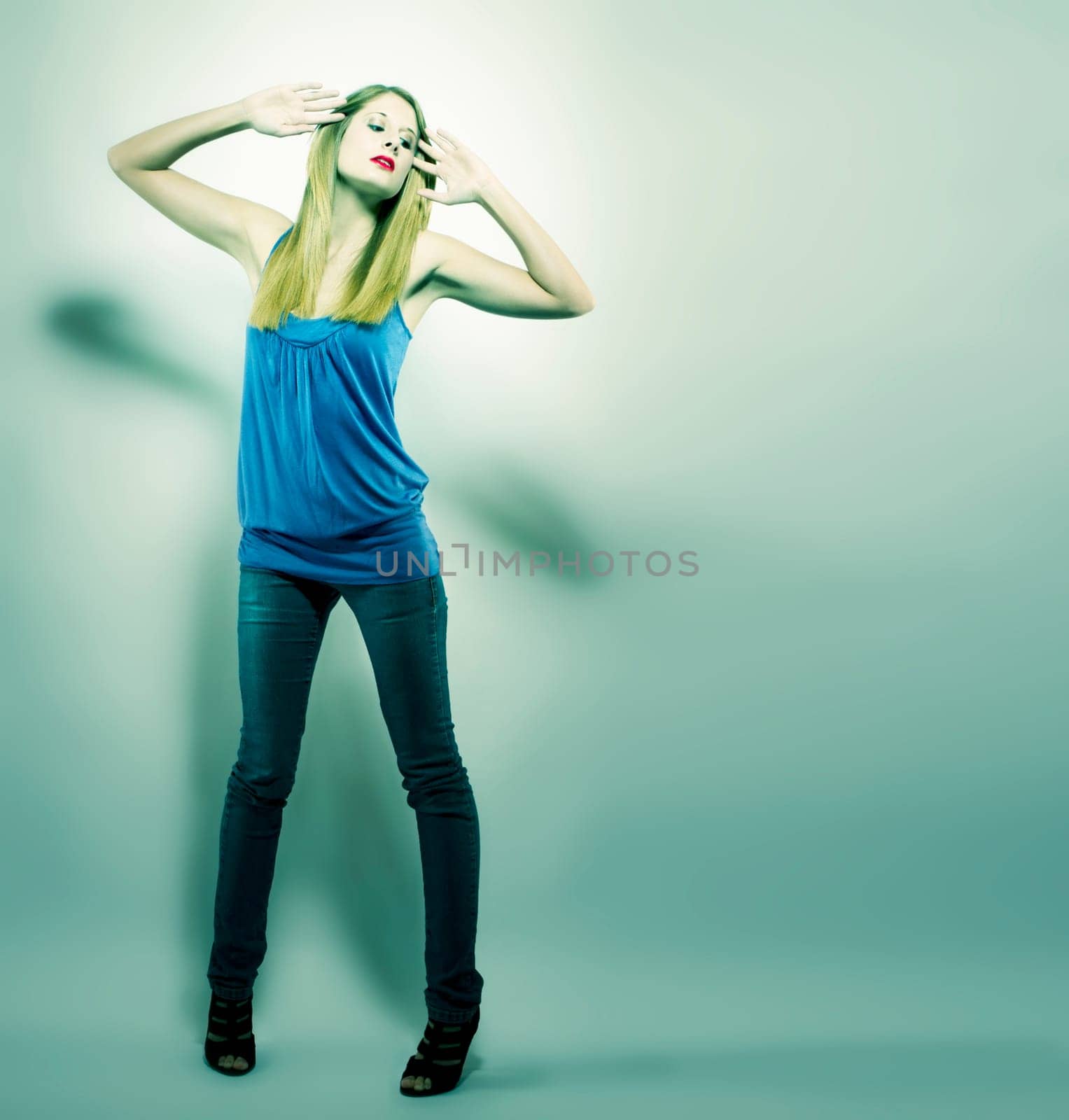 Young woman in jeans and shirt in green light