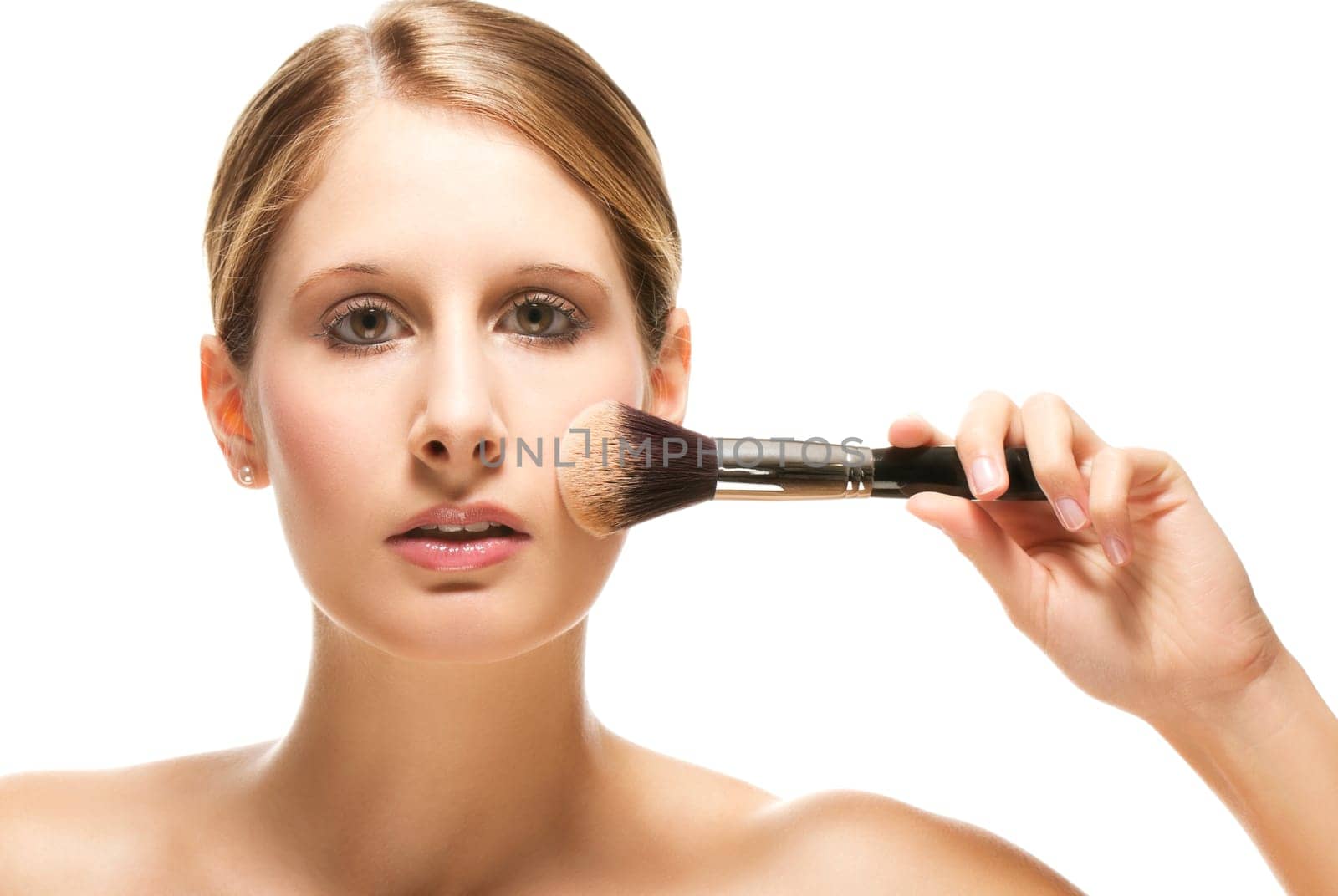 Young woman applying makeup on white background