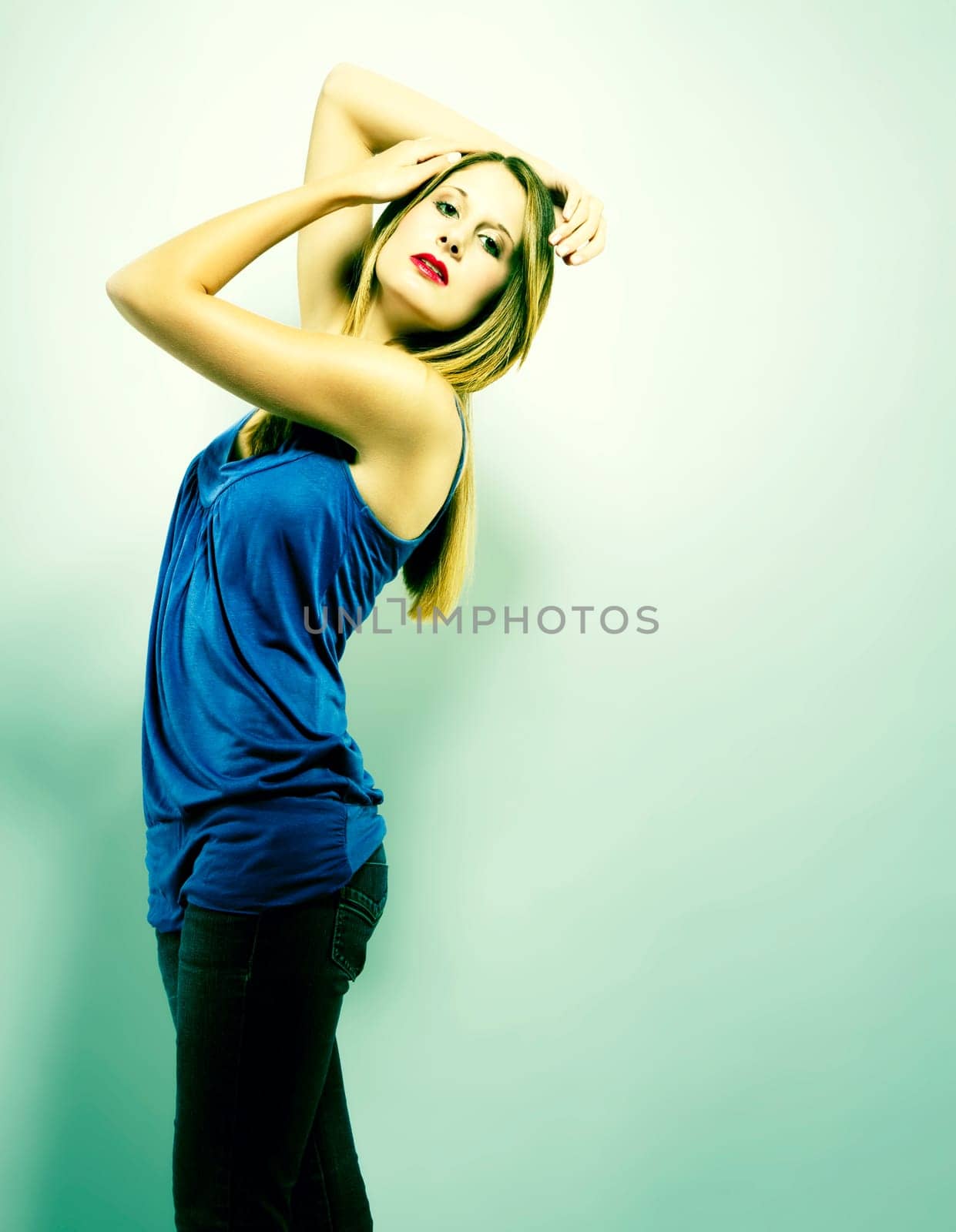 Young beautiful woman in fashion pose in green light
