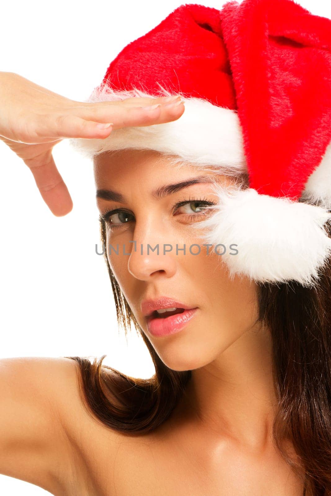 Young woman in Santa hat looking into the distance on white background