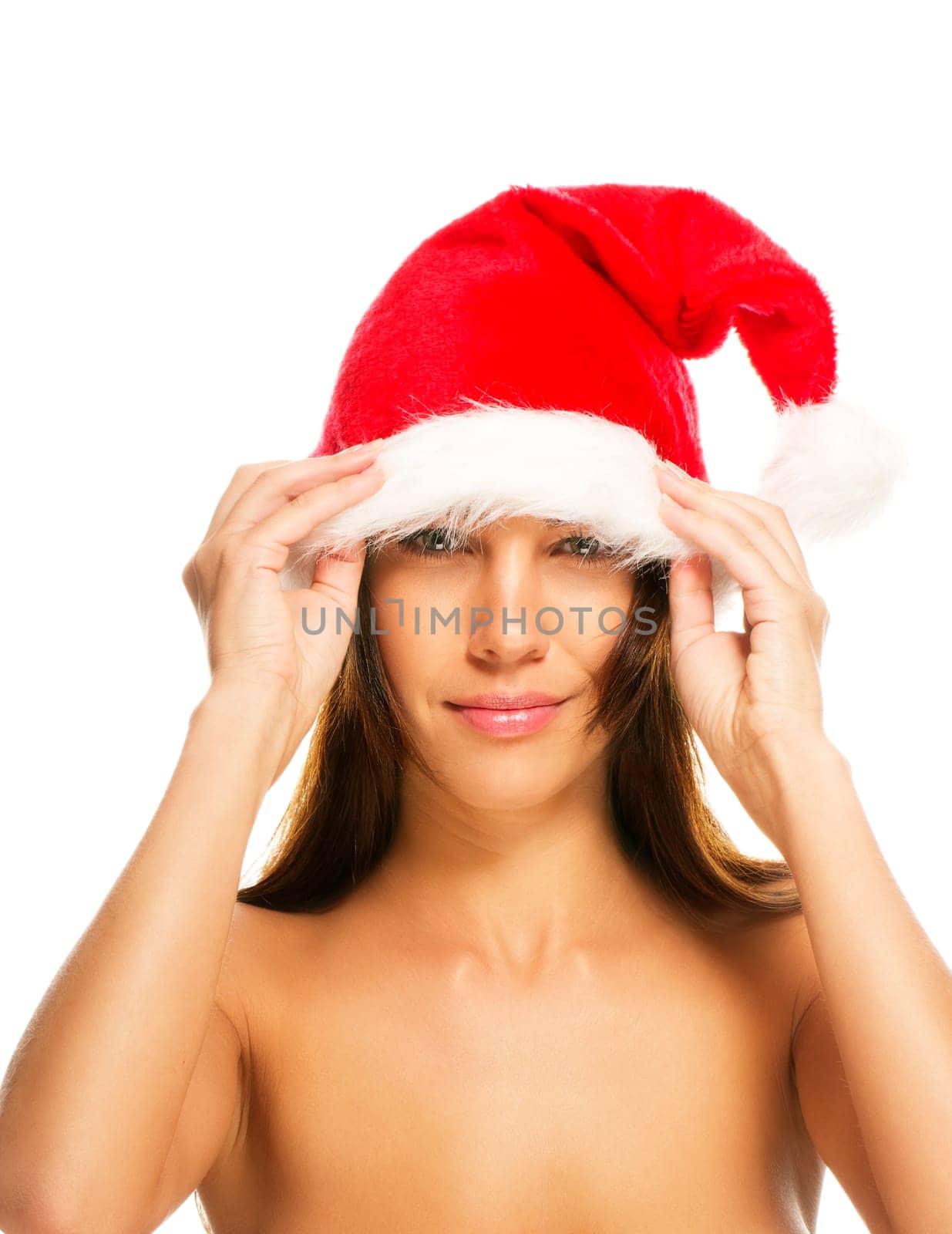 Young woman putting on Santa hat on white background