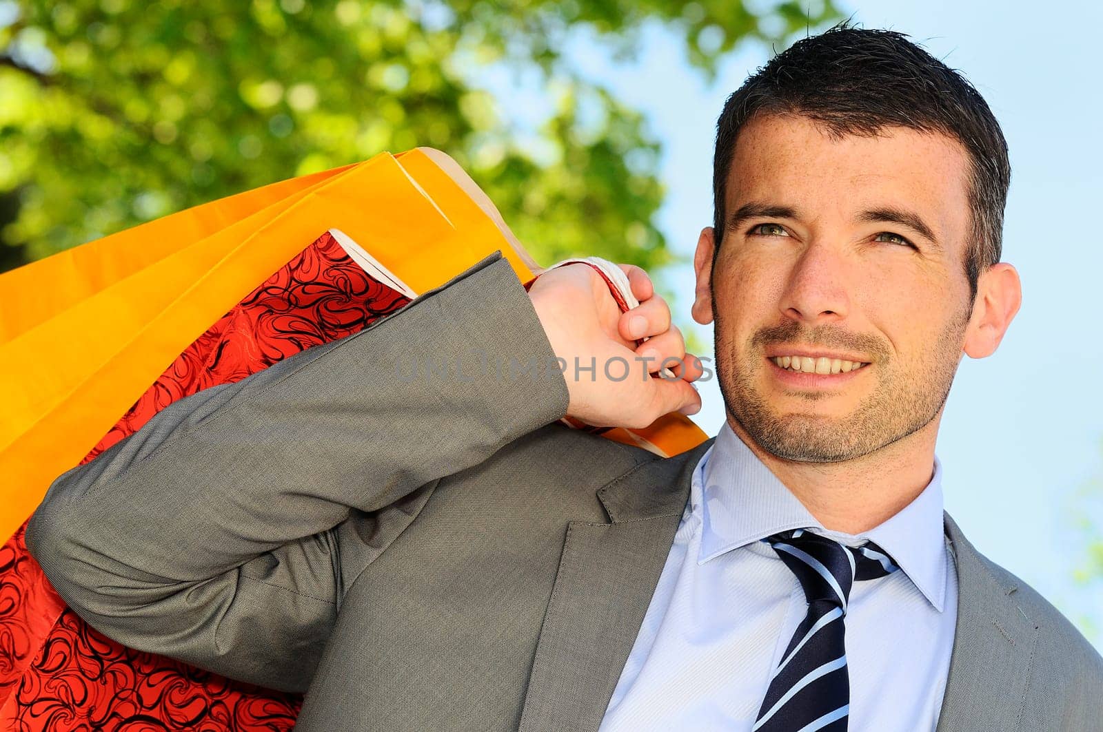 great businessman outdoor with colored shopping bags