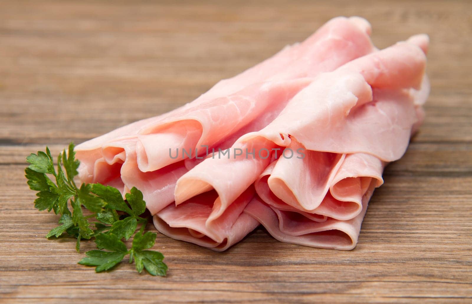 slices of ham on wooden background