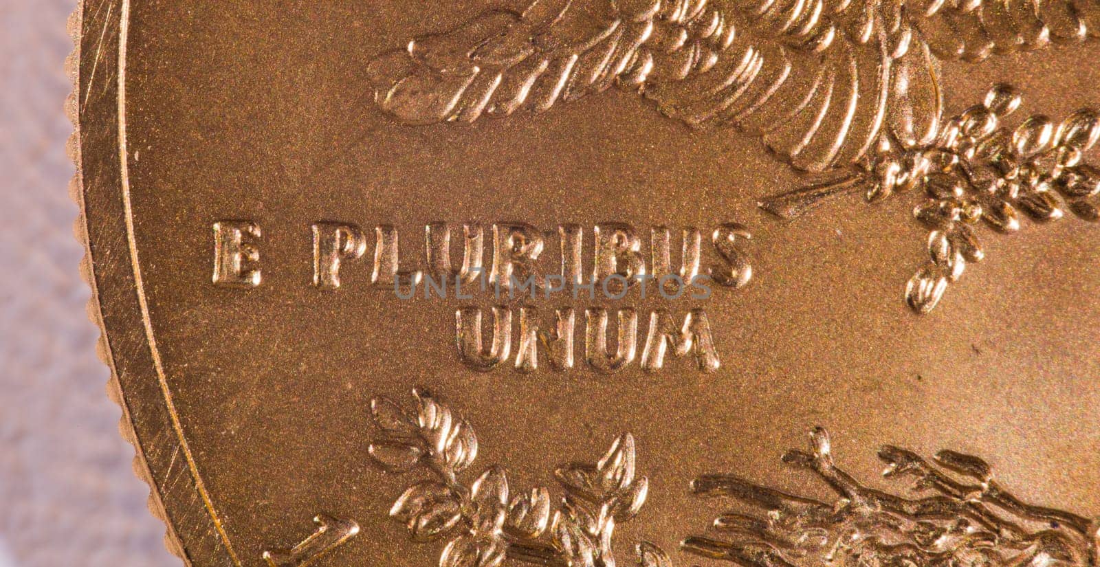 Gold Eagle one ounce coins with macro shot of the engraving of E Pluribus Unum