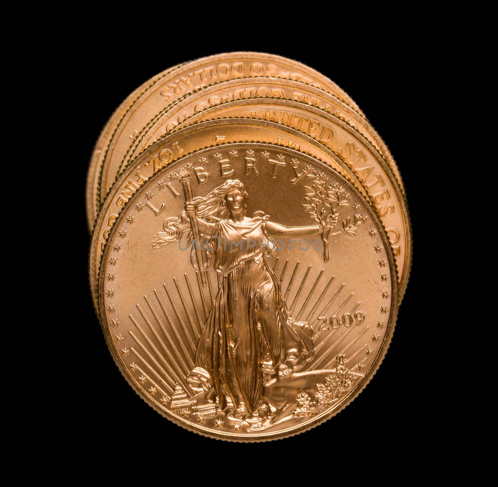 Gold Eagle one ounce coins in a stack and isolated against black