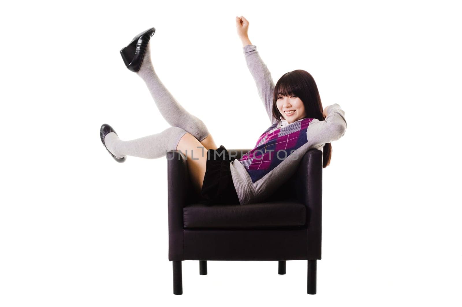Chinese student in a school uniform sitting in a leather chair.