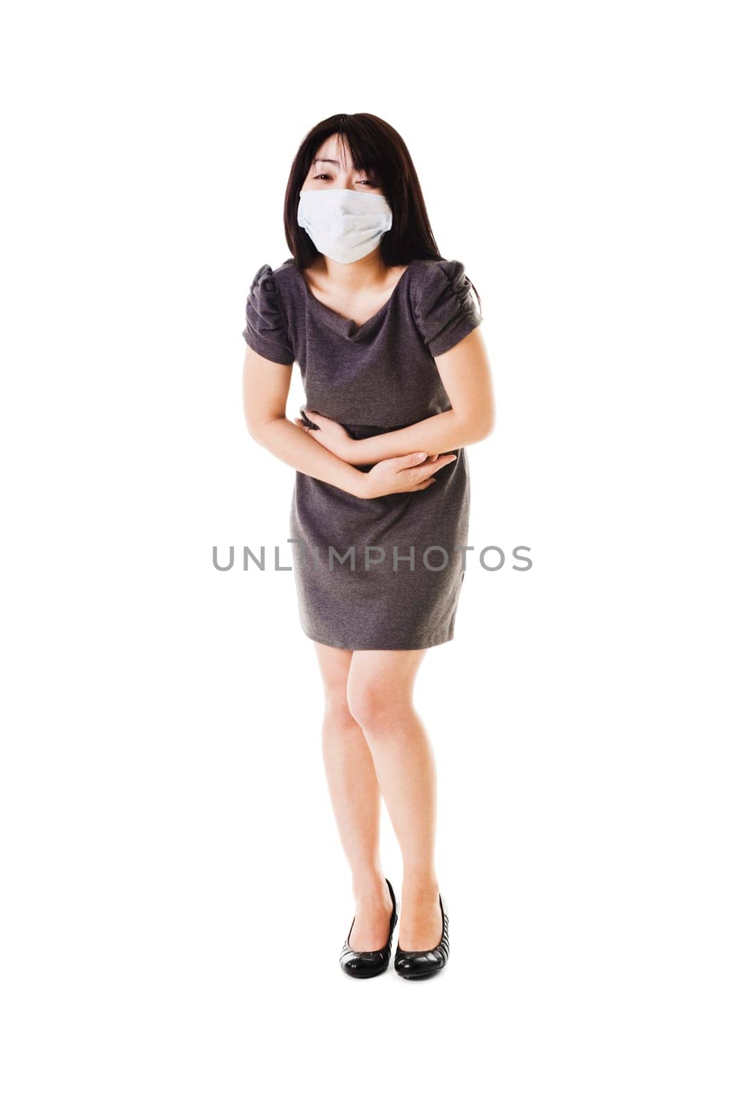Sick fashionable Chinese woman wearing a face mask holds her stomach.