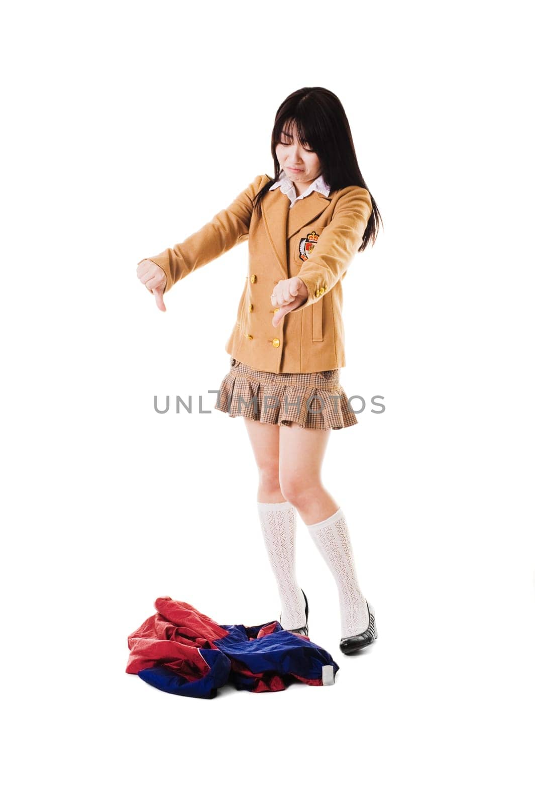 Fashionable Chinese school girl wearing a Japanese style school uniform disapproves of an ugly looking Chinese uniform.