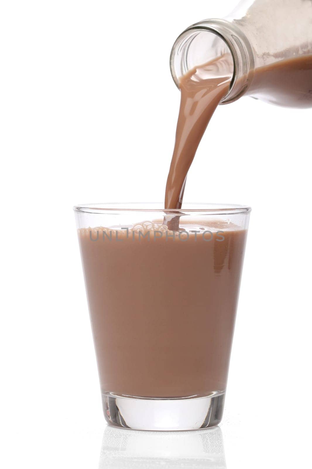 Bottle pouring milk chocolate into a glass