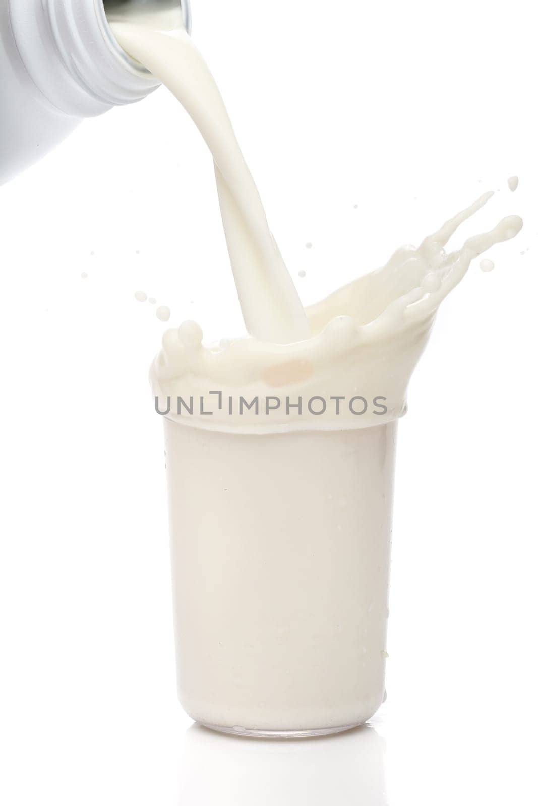 Bottle pouring milk into a glass. Splash
