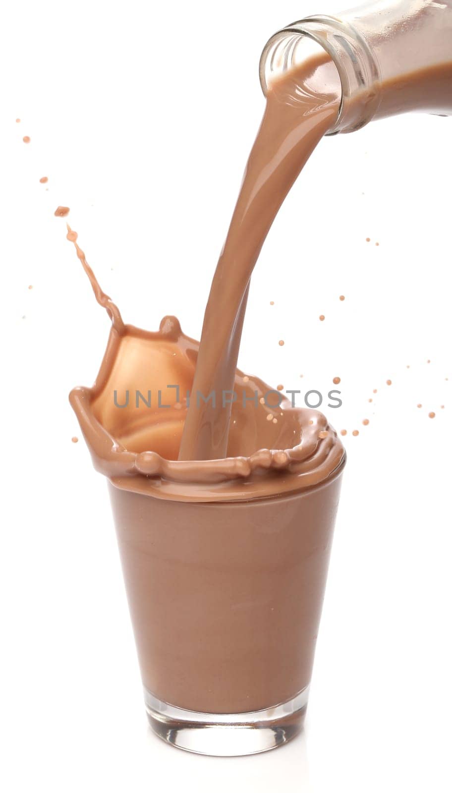 Bottle pouring milk chocolate into a glass
