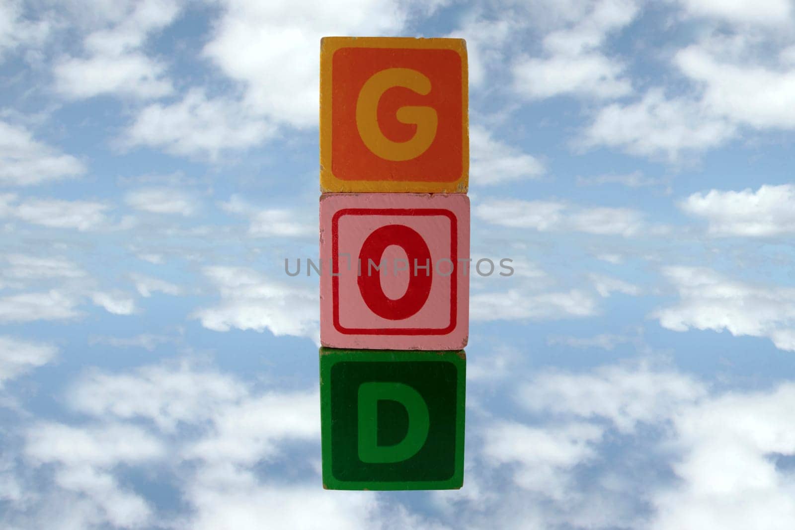 childrens toy letter building blocks against a cloudy background spelling god with clipping path