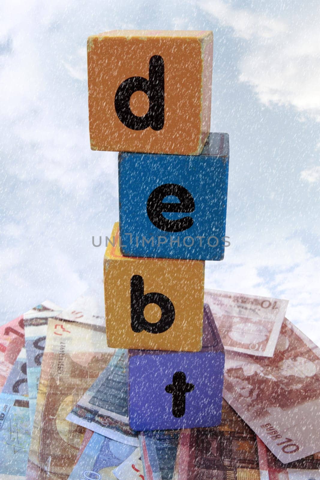 assorted childrens toy letter building blocks against a stormy background on money that spell debt