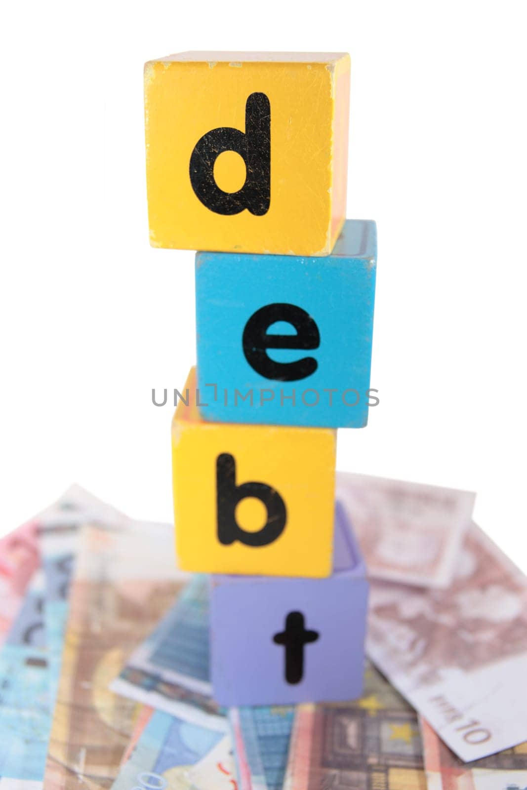 assorted childrens toy letter building blocks against a white background on money that spell debt