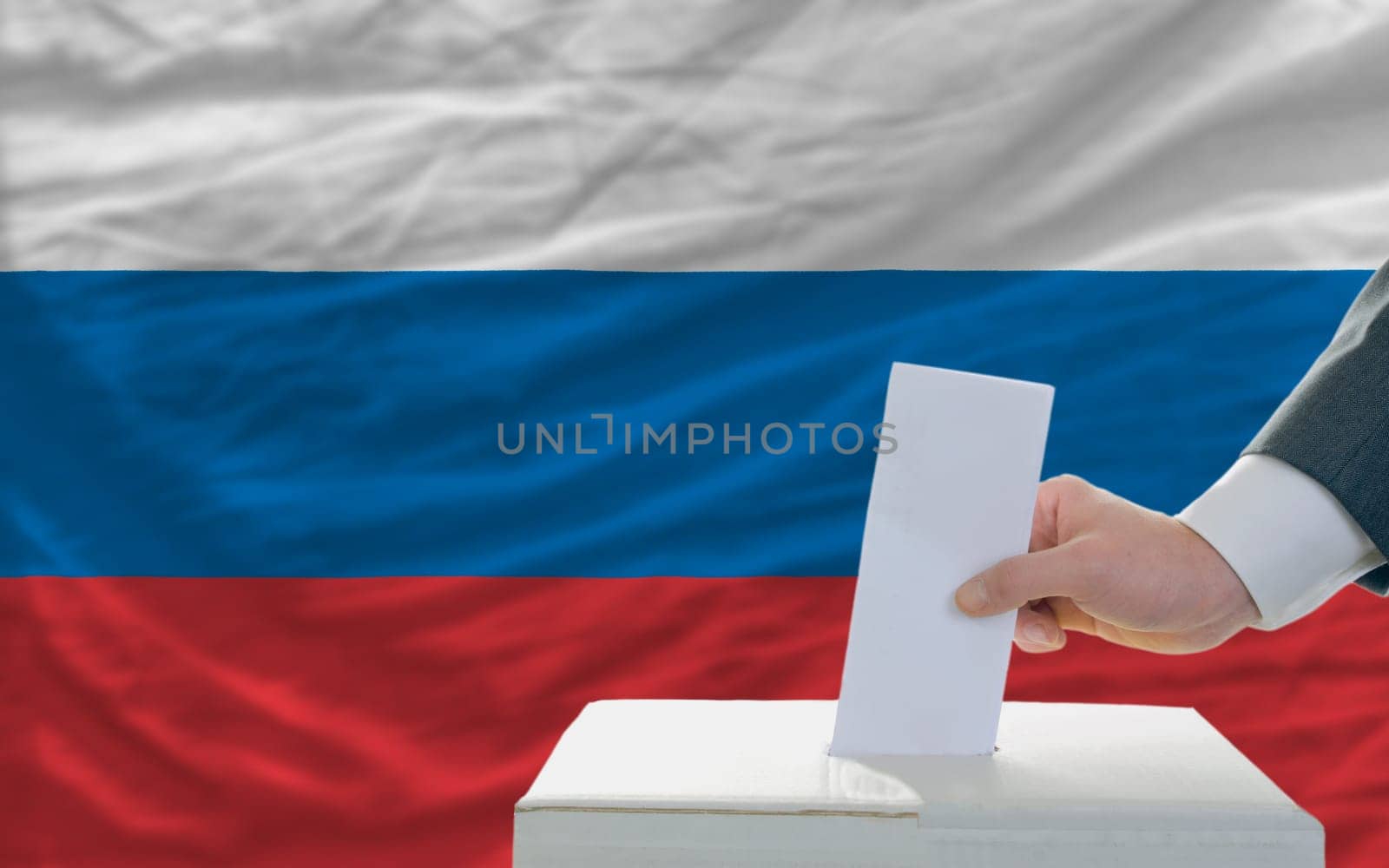 man putting ballot in a box during elections in russia