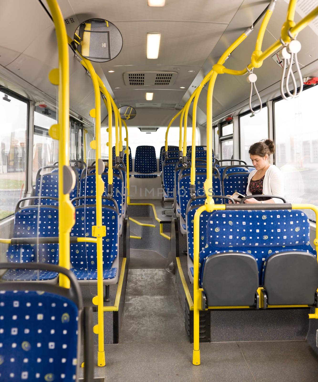 Young woman with a book alone on the bus