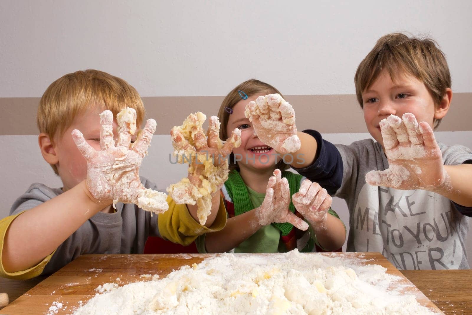 Children knead dough to bake cookies for Christmas