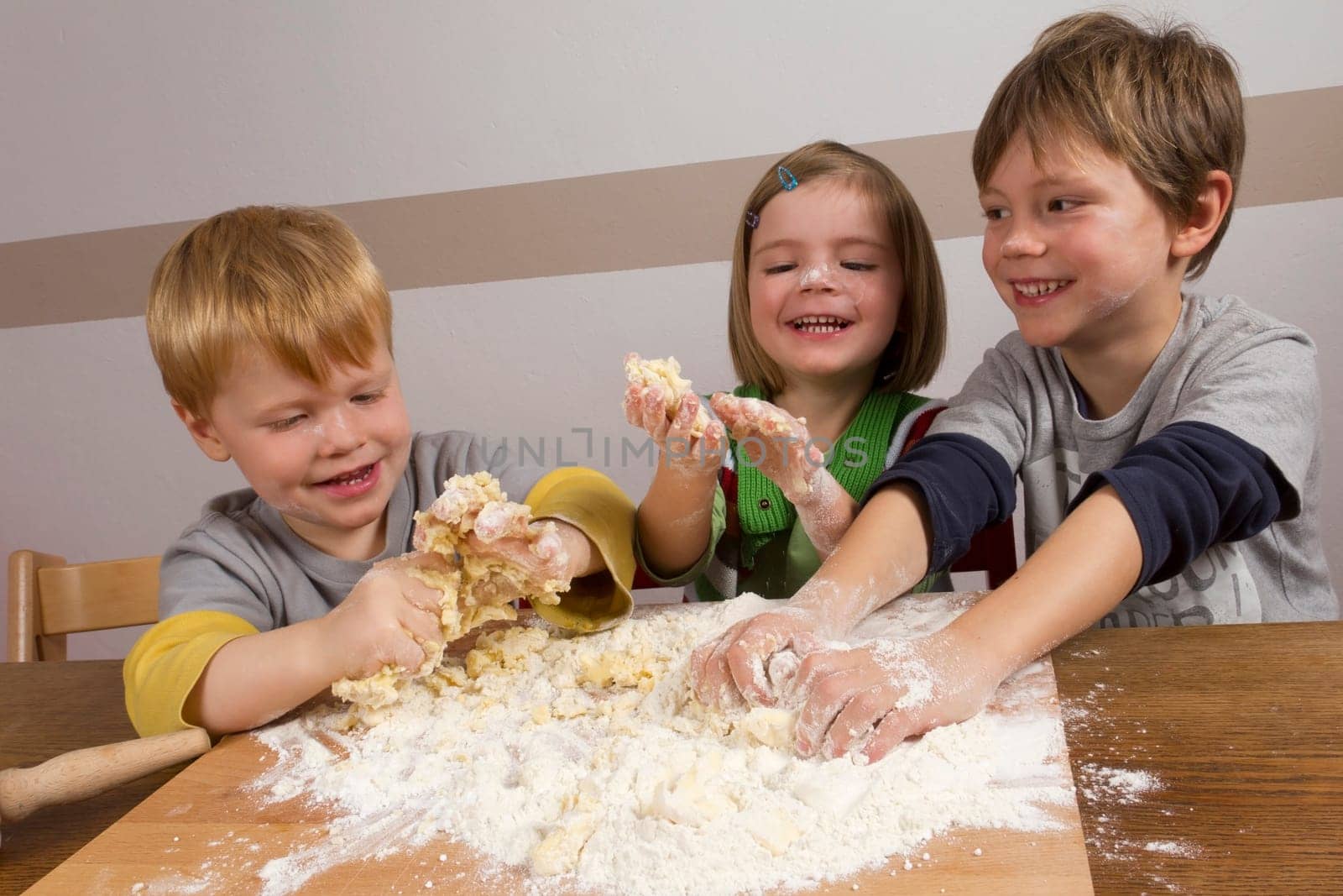 Children knead dough and have a lot of fun