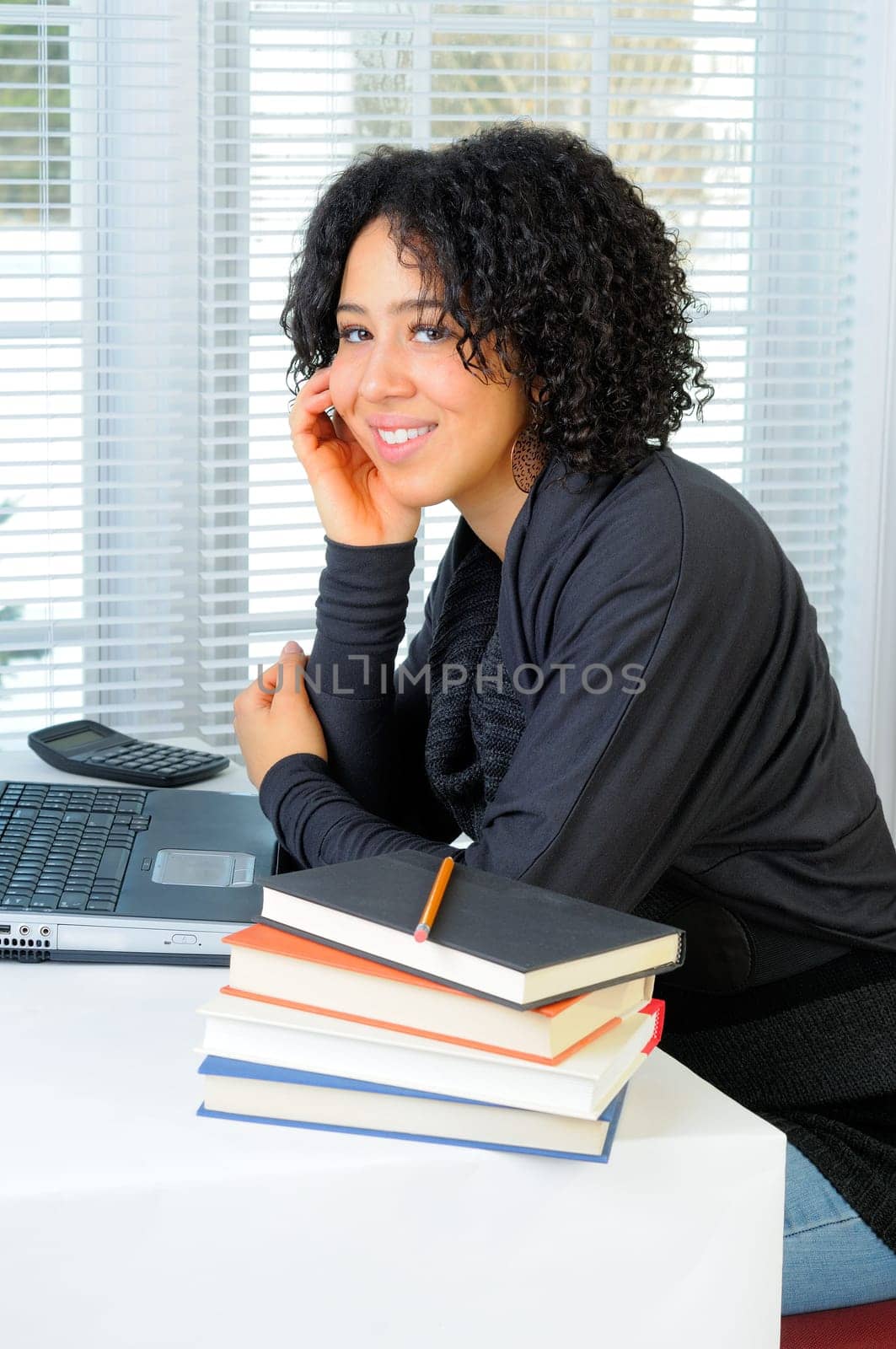 Young Woman Sat At Her Desk Using A Laptop Computer In Class At School