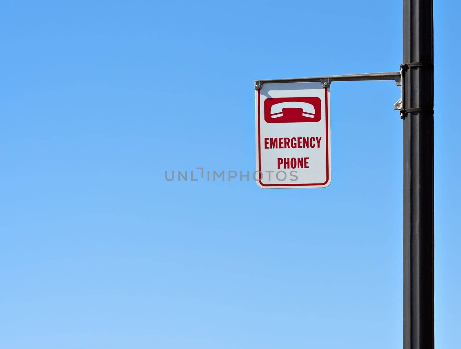 Emergency phone sign with a blue sky background