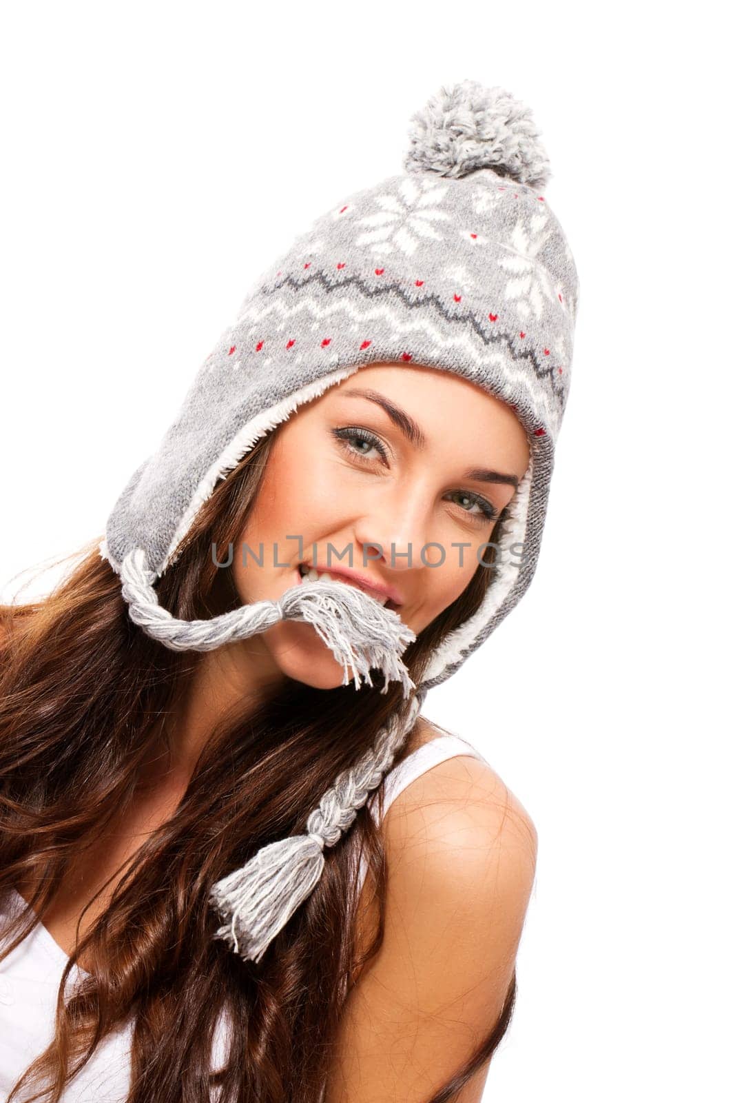 Beautiful brunette woman holding part of her winter hat in mouth on white background