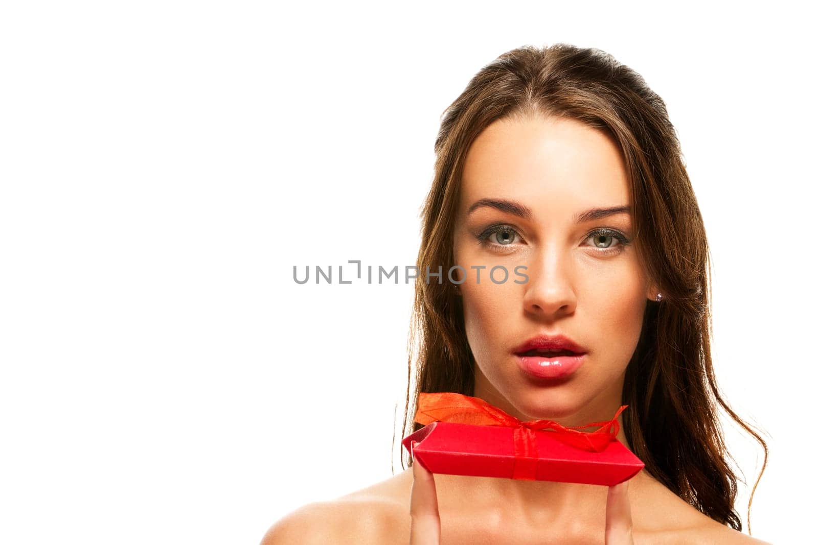 Beautiful woman holding gift with fingers on white background
