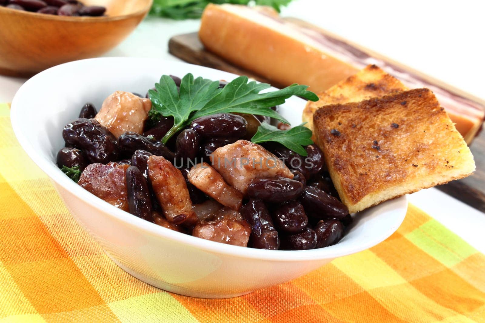 a bowl of kidney beans,parsley and fried bacon