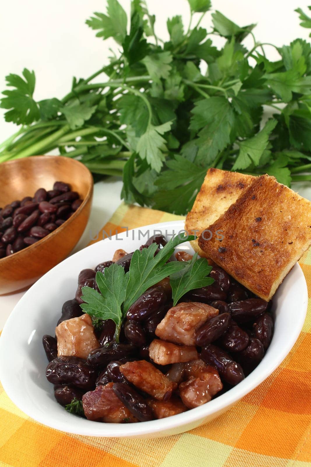 a bowl of kidney beans,parsley and fried bacon