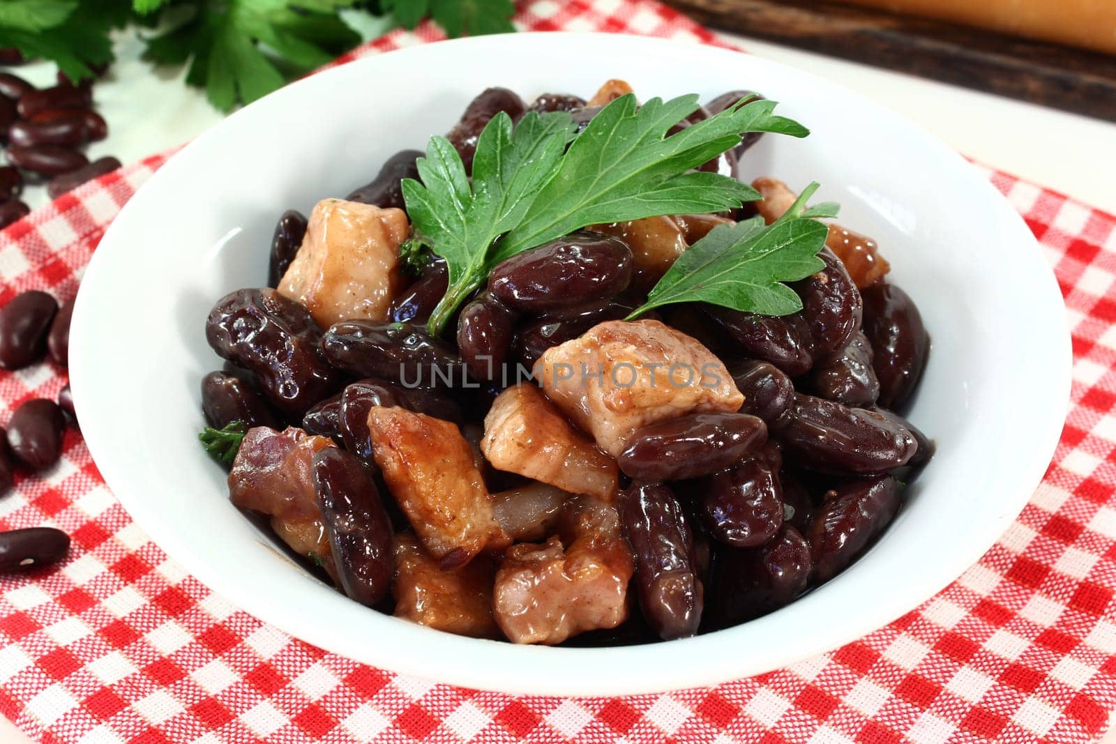 a bowl of kidney beans,parsley and fried bacon