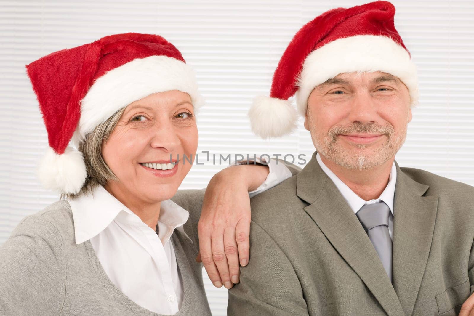Laughing senior businesspeople having fun with Xmas Santa hat