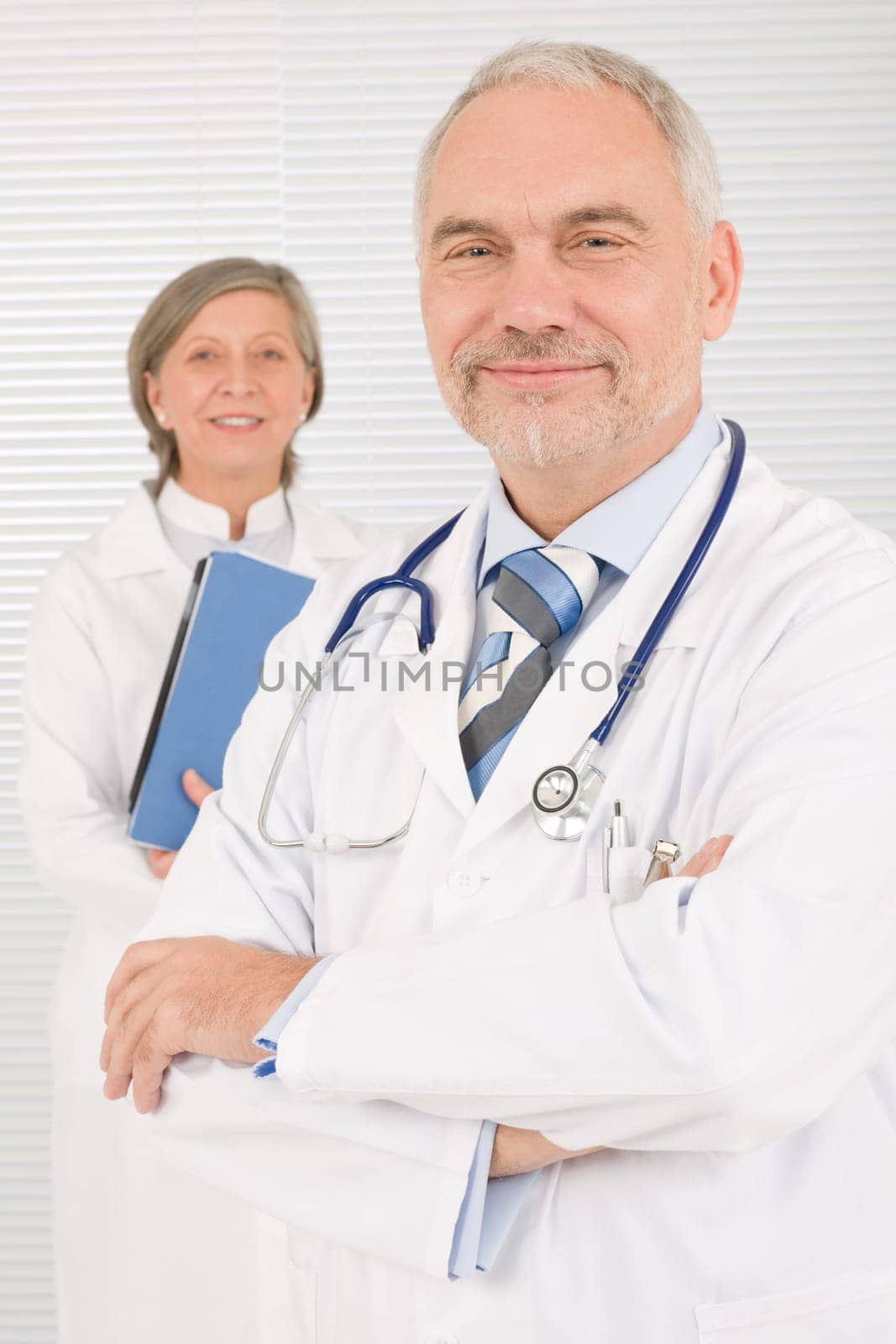 Medical doctor team mature woman and senior man holding folders