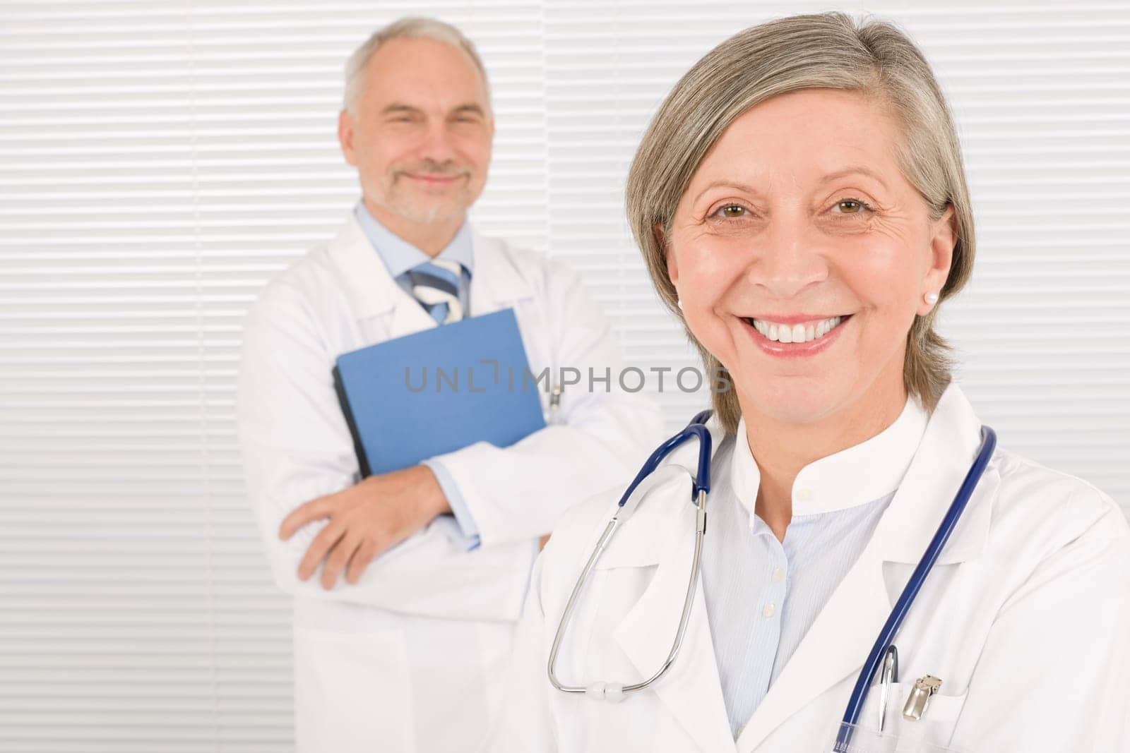 Medical doctor team mature woman and senior man holding folders