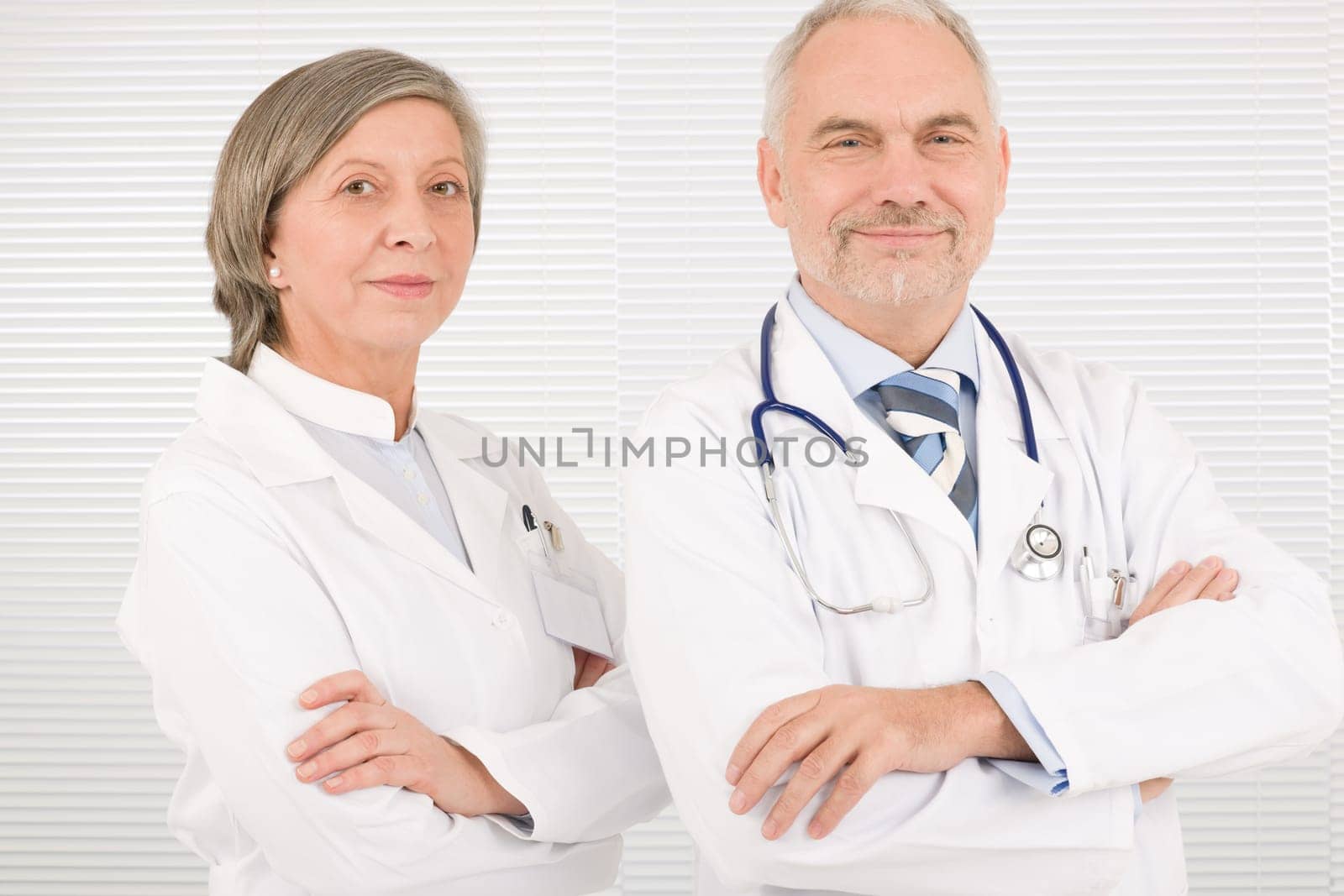 Medical team senior male doctor with professional female colleague portrait