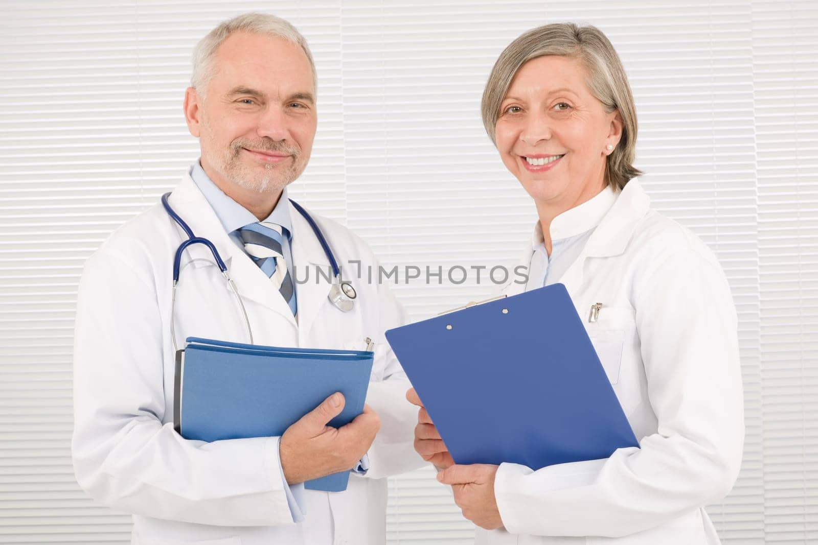 Medical doctor team senior woman and mature man holding folders