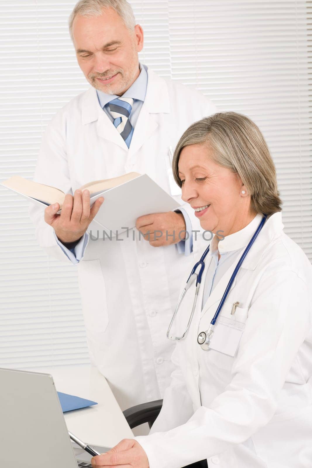 Medical senior doctor female look computer with professional male colleague