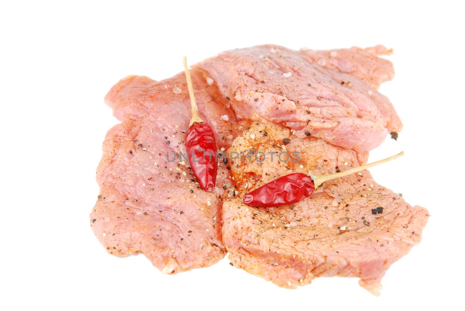 raw pork meat with red pepper ready to be cooked (over white)